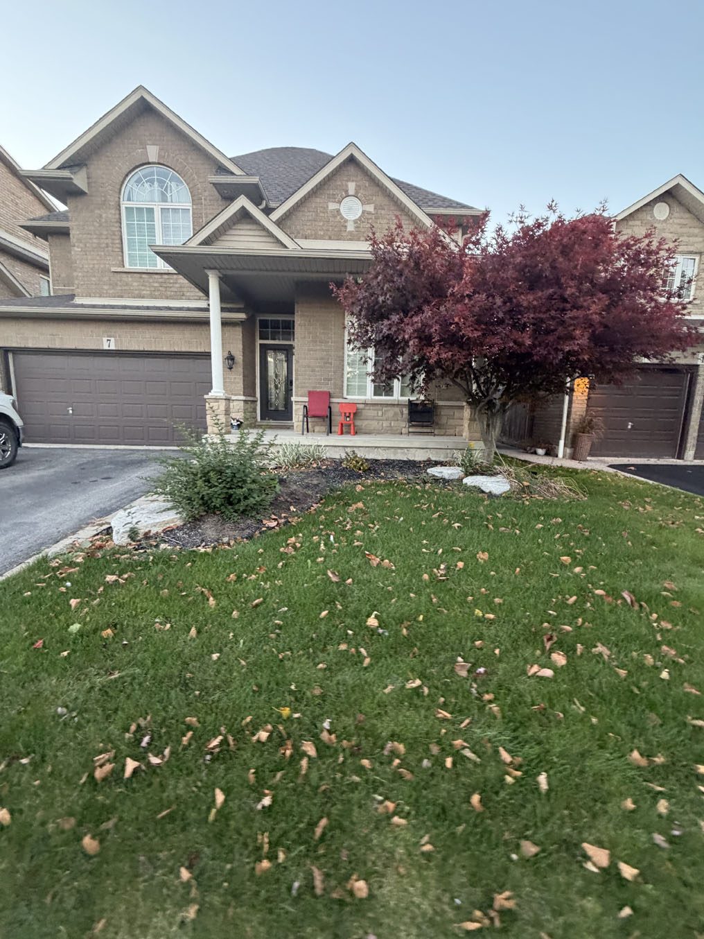 Front lawn before a covered porch and red Japanese maple in Hamilton