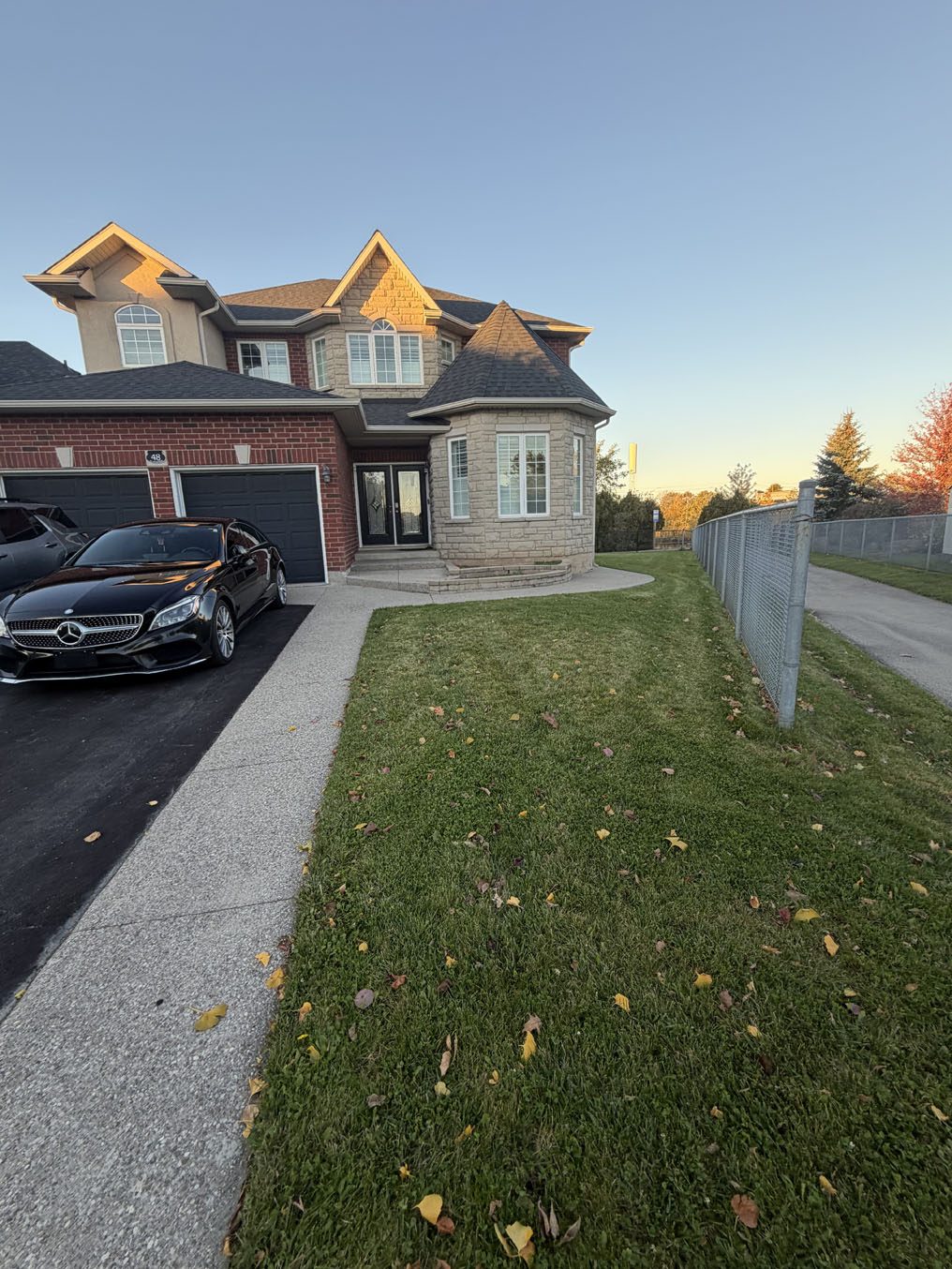 Sodded front lawn beside a long concrete driveway at sunset, a Right On Sod job in Hamilton, Ontario