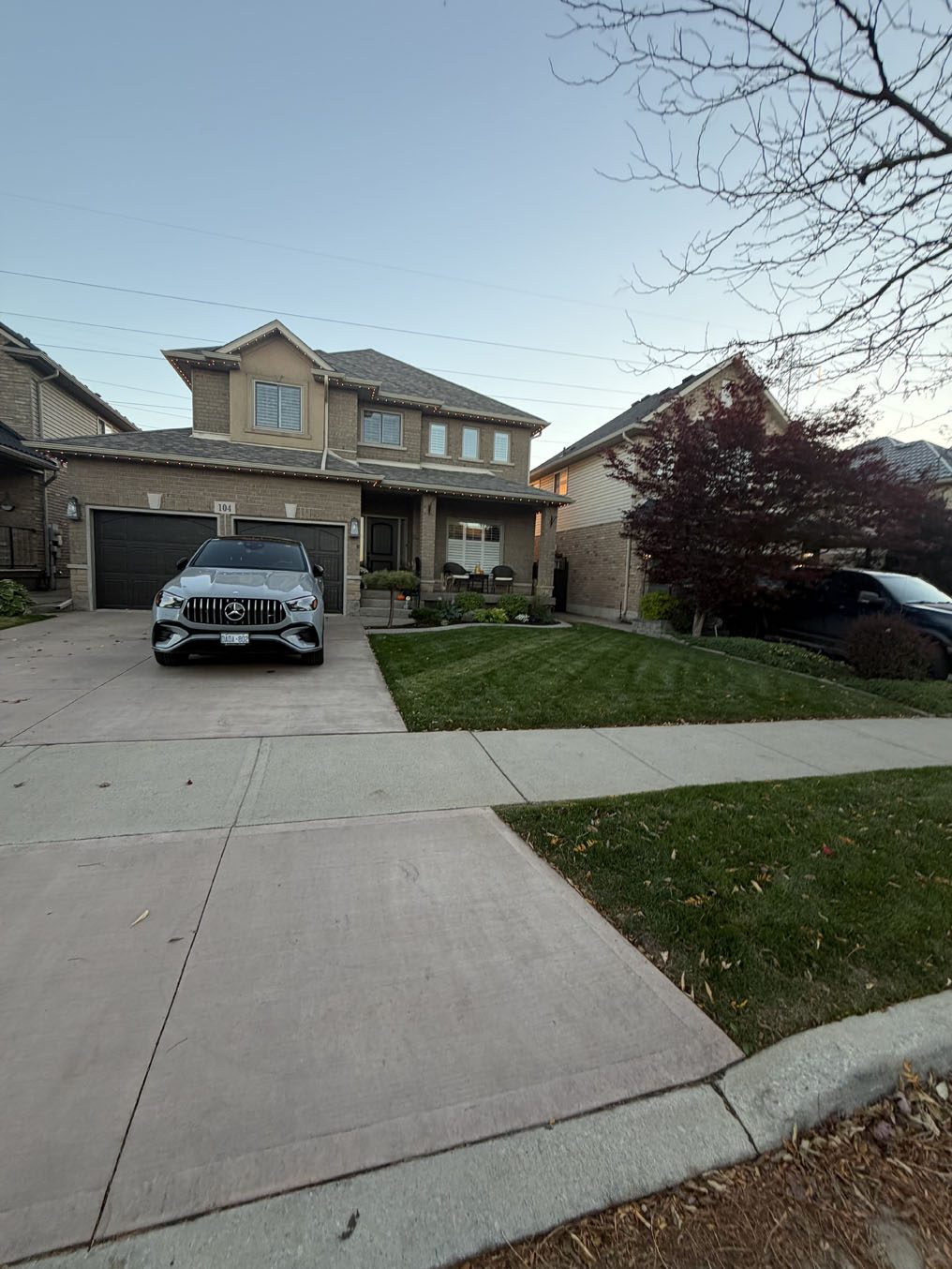 Narrow lawn strips beside a wide concrete driveway in a Hamilton subdivision